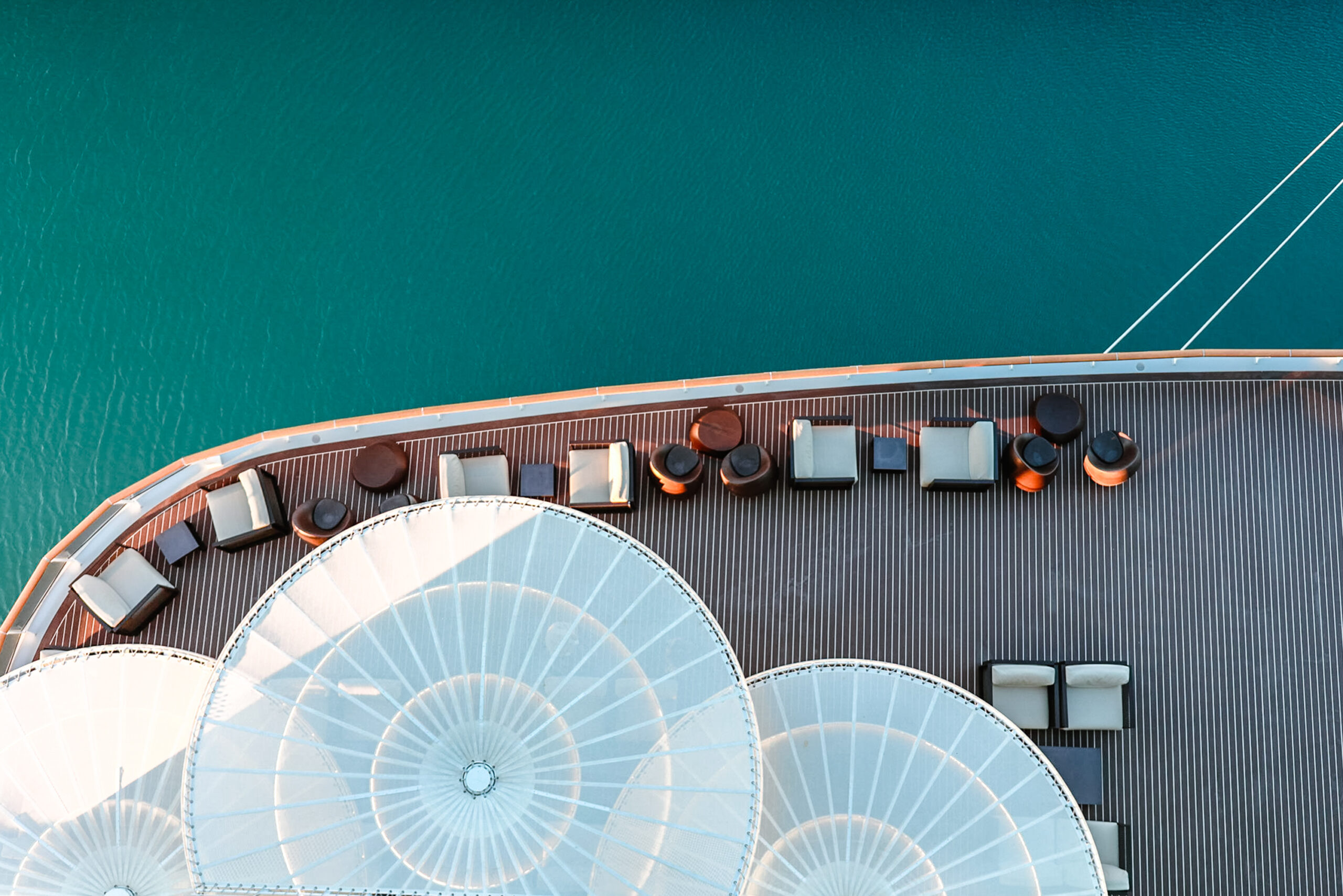 Lounge promenade deck on cruise ship. Interior of luxury cruise restaurant with tables and armchair in sunset at sea